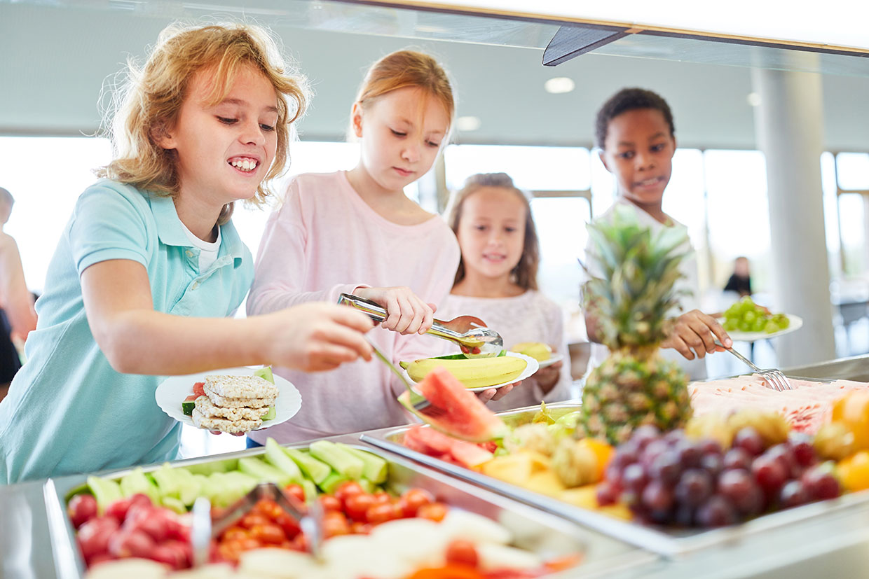 Photo enfants choisissent des fruits dans une cantine santé alimentation