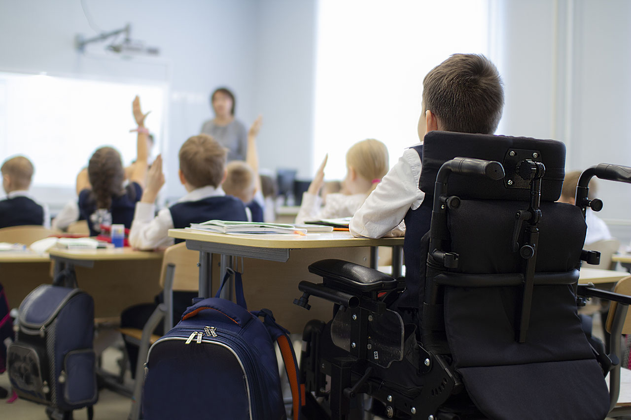 Photo élève en fauteuil dans une classe handicap école inclusive inclusion