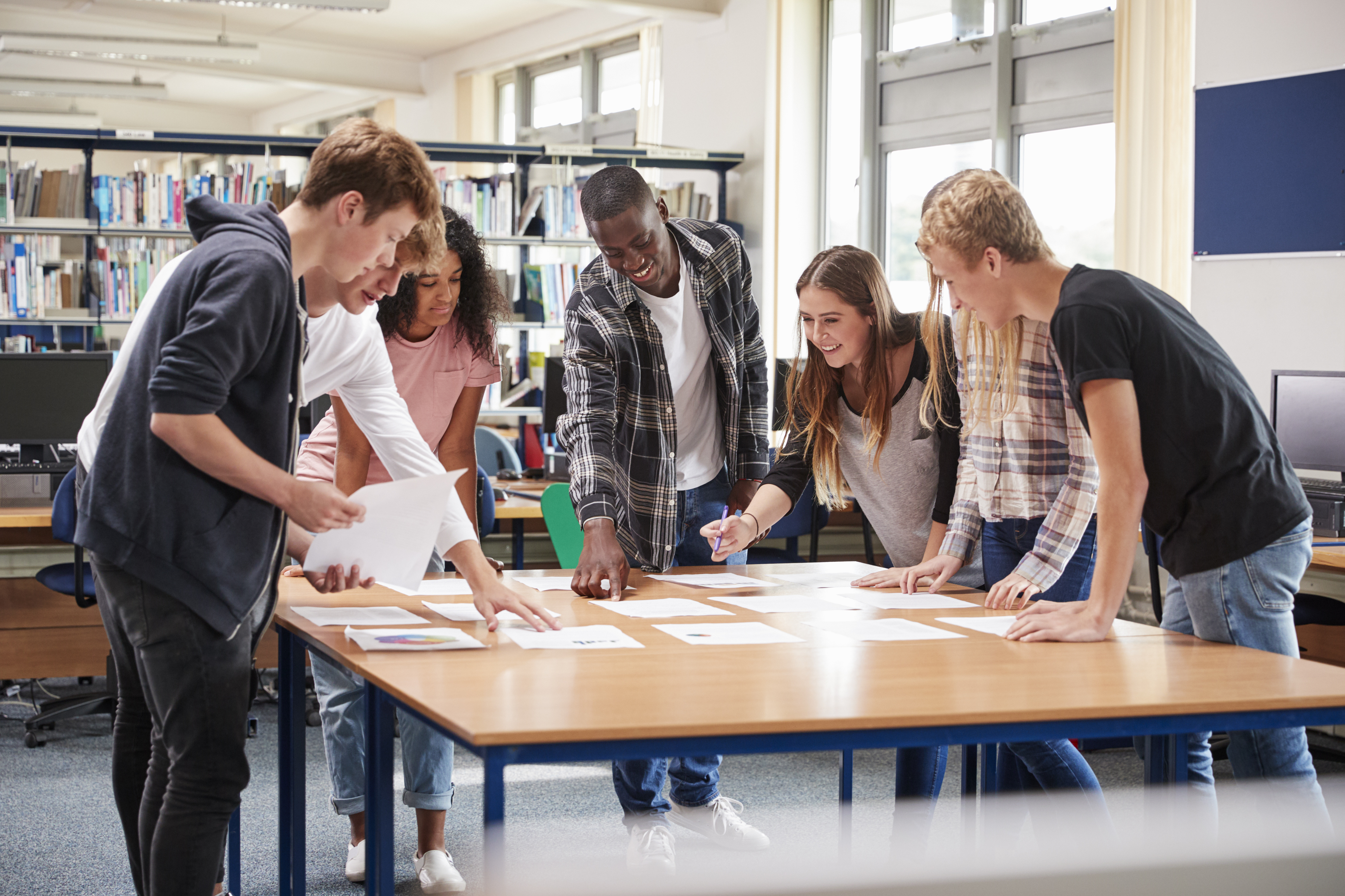 Photo élèves adolescents debout autour d'une table