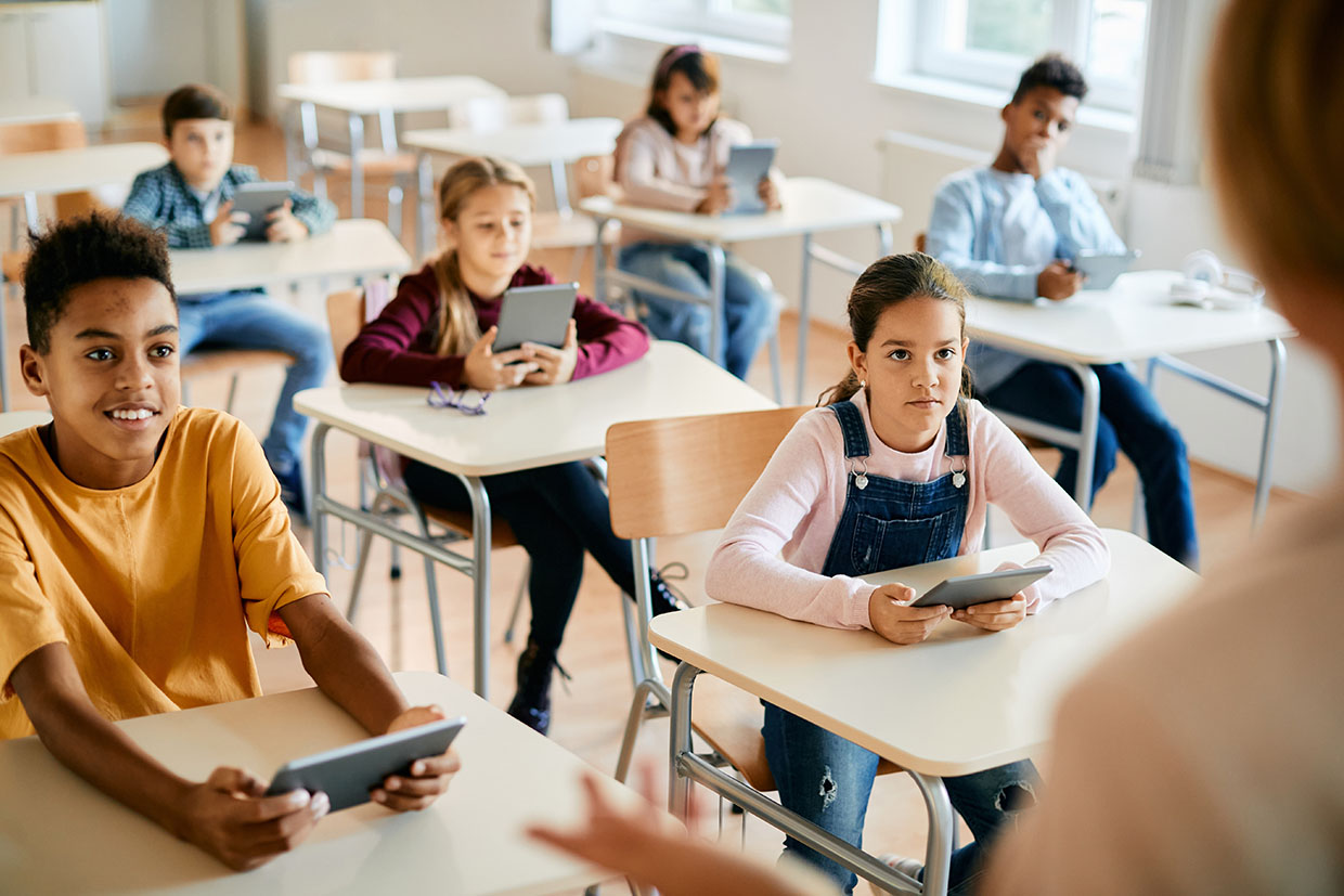 Photo élèves école élémentaire primaire avec des tablette enseignant de dos numérique