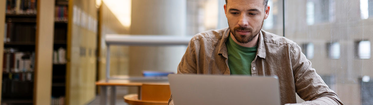 Photo homme révise ou étudie à la bibliothèque préparation examen concours révision