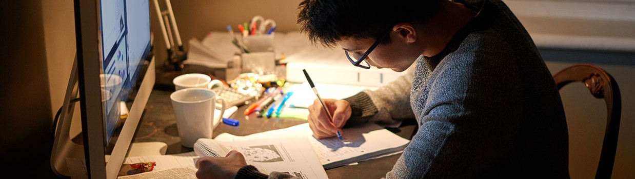 Photo lycéen élève fait ses devoirs devant un ordinateur à la maison 