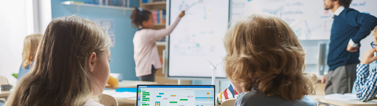 photo deux élèves en classe devant un ordinateur numérique