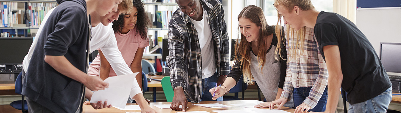 Photo élèves lycéens collégiens autour d'une table en groupe dans une classe'