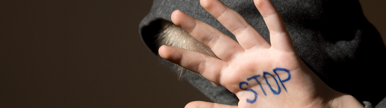 Photo main d'enfant avec le mot stop harcèlement discrimination
