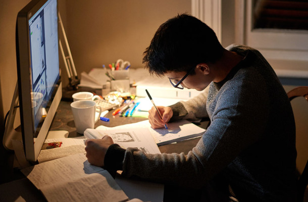 Photo lycéen élève fait ses devoirs devant un ordinateur à la maison 