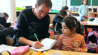 Enseignant qui écrit dans le cahier de l'élève