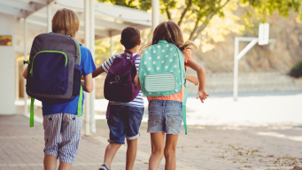 Photo trois élèves avec des sacs à dos dans la cour d'un eple