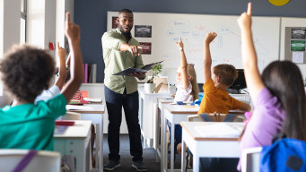 Photo enseignant professeur interroge à l'école les élèves école élémentaire primaire 