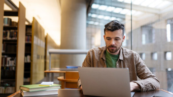 Photo homme révise ou étudie à la bibliothèque préparation examen concours révision