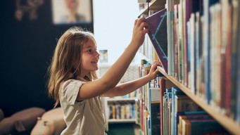 Photo élève enfant fille prend un livre dans un bibliothèque cdi lecture plaisir