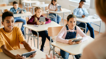 Photo élèves école élémentaire primaire avec des tablette enseignant de dos numérique