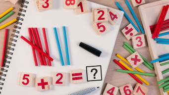photo avec des chiffres de couleur sur un cahier et des crayons mathématiques 