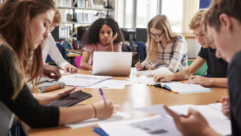 Photo élèves en groupe autour d'une table dans une classe collégien lycéen